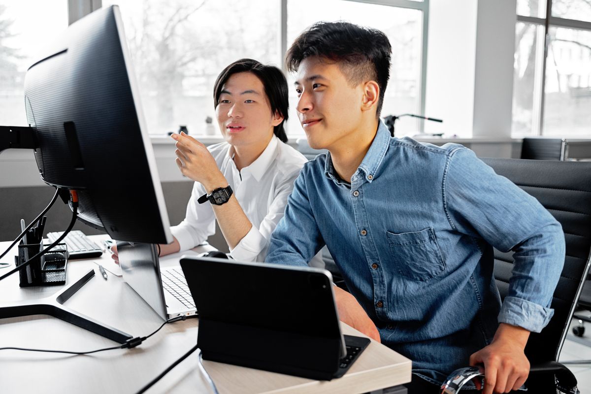 Two teammates checking data on screen